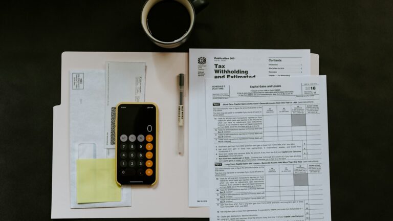 Documentación administrativa y calculadora sobre una mesa