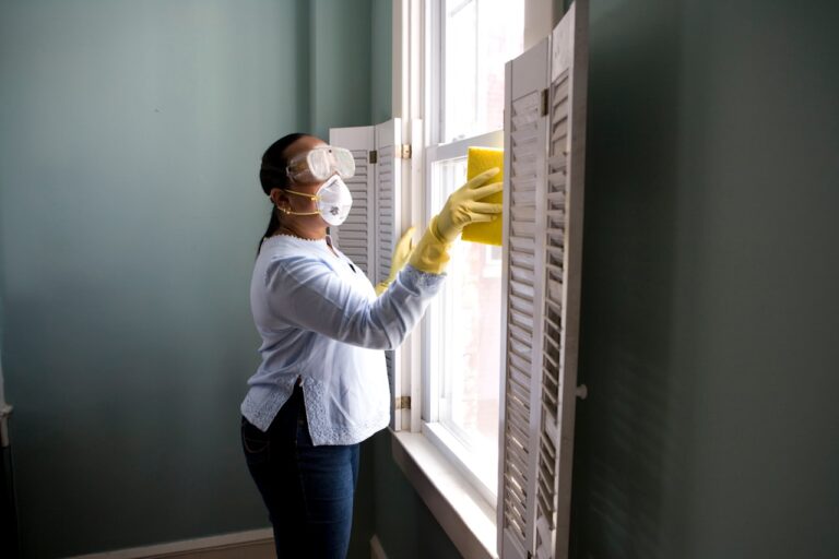 Profesional de limpieza limpiando una ventana